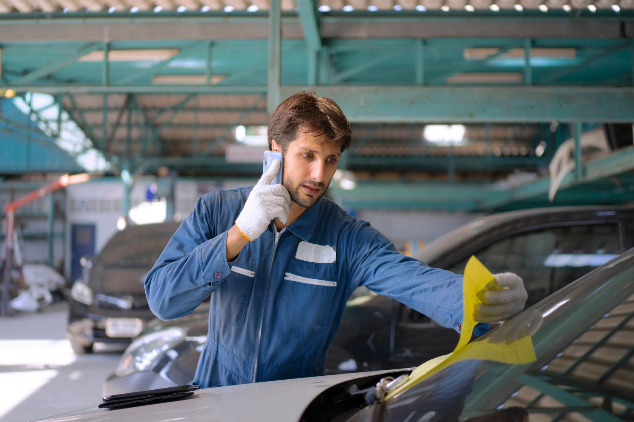 Mobile detailing business owner working in a garage beside a vehicle